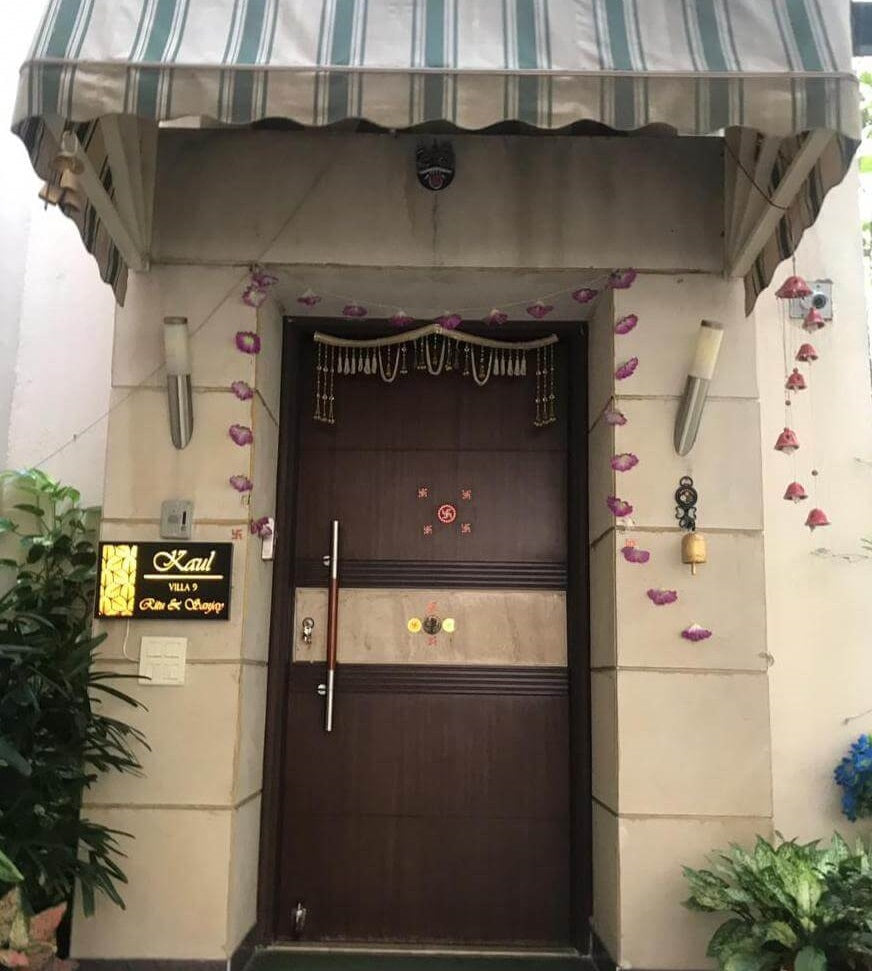 a name plate with light fixed outside a big door.