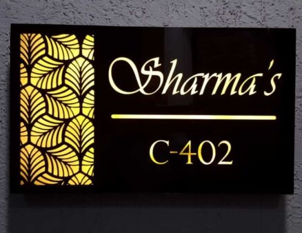 a name plate with light fixed on a textured white wall